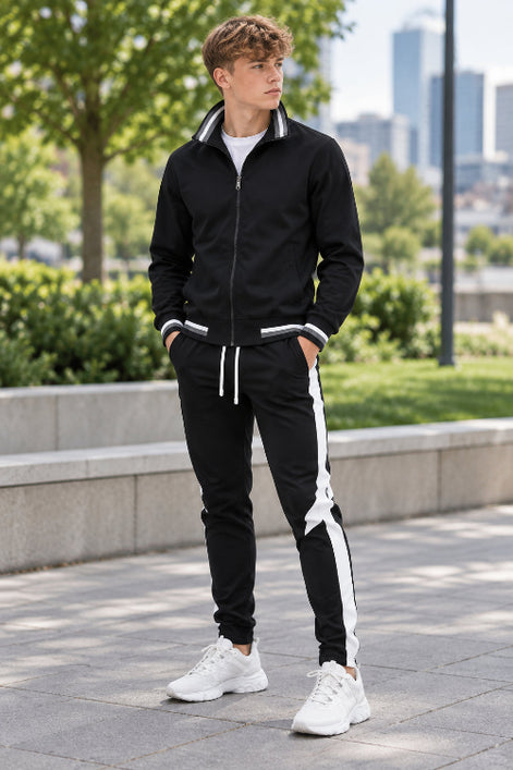 Black tracksuit with white stripes on pants and white sneakers on a white background