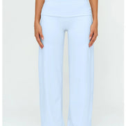 A model wearing light blue wide-leg yoga pants and a matching light blue sports bra, shown from the chest down against a plain white studio background.