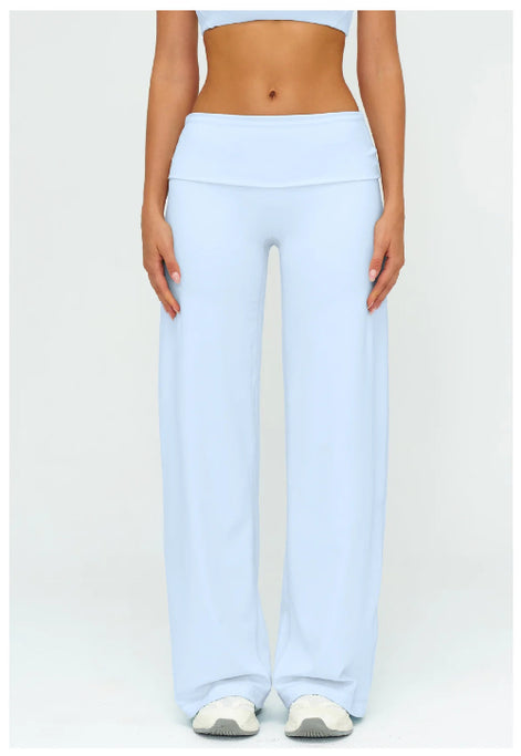 A model wearing light blue wide-leg yoga pants and a matching light blue sports bra, shown from the chest down against a plain white studio background.