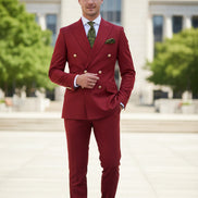 Red suit jacket and pants on a mannequin with a green tie and pocket square against a white background