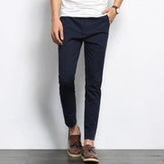 Person wearing navy pants and brown shoes against a white background