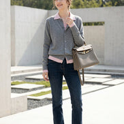 A person taking a mirror selfie wearing a gray button-up cardigan over a light pink top, paired with dark blue jeans