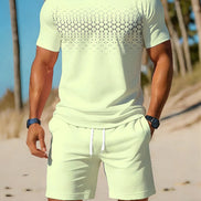 A man wearing a light yellow-green short-sleeve t-shirt with a black geometric pattern across the chest