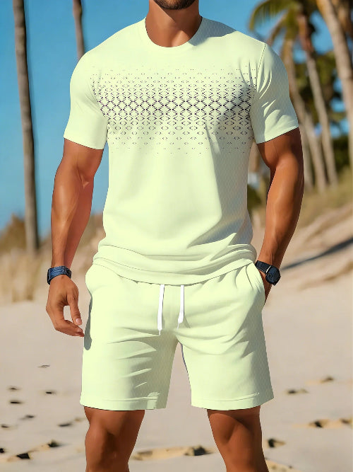 A man wearing a light yellow-green short-sleeve t-shirt with a black geometric pattern across the chest