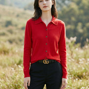 Red sweater with gold buttons worn by a person, blurred background