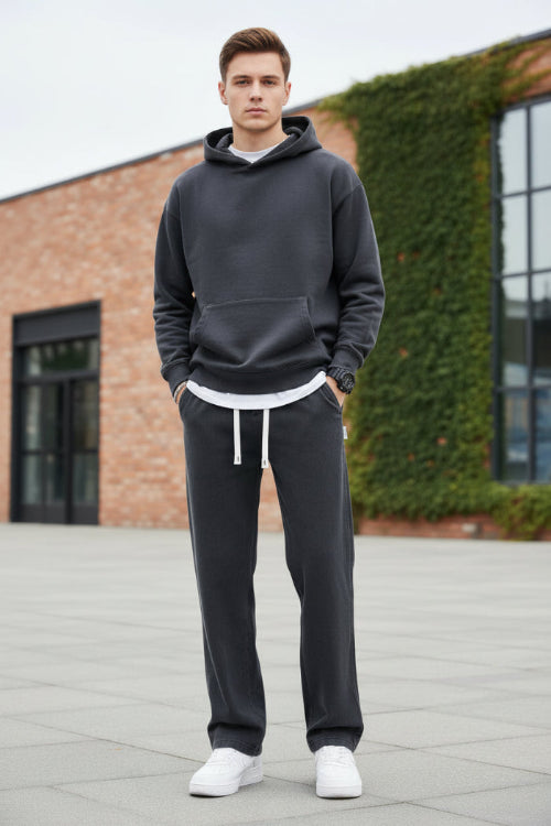 Person wearing black pants with white drawstrings on a gray background