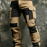 Khaki and black color-block cargo pants with flap thigh pockets and a black belt against a textured gray background.