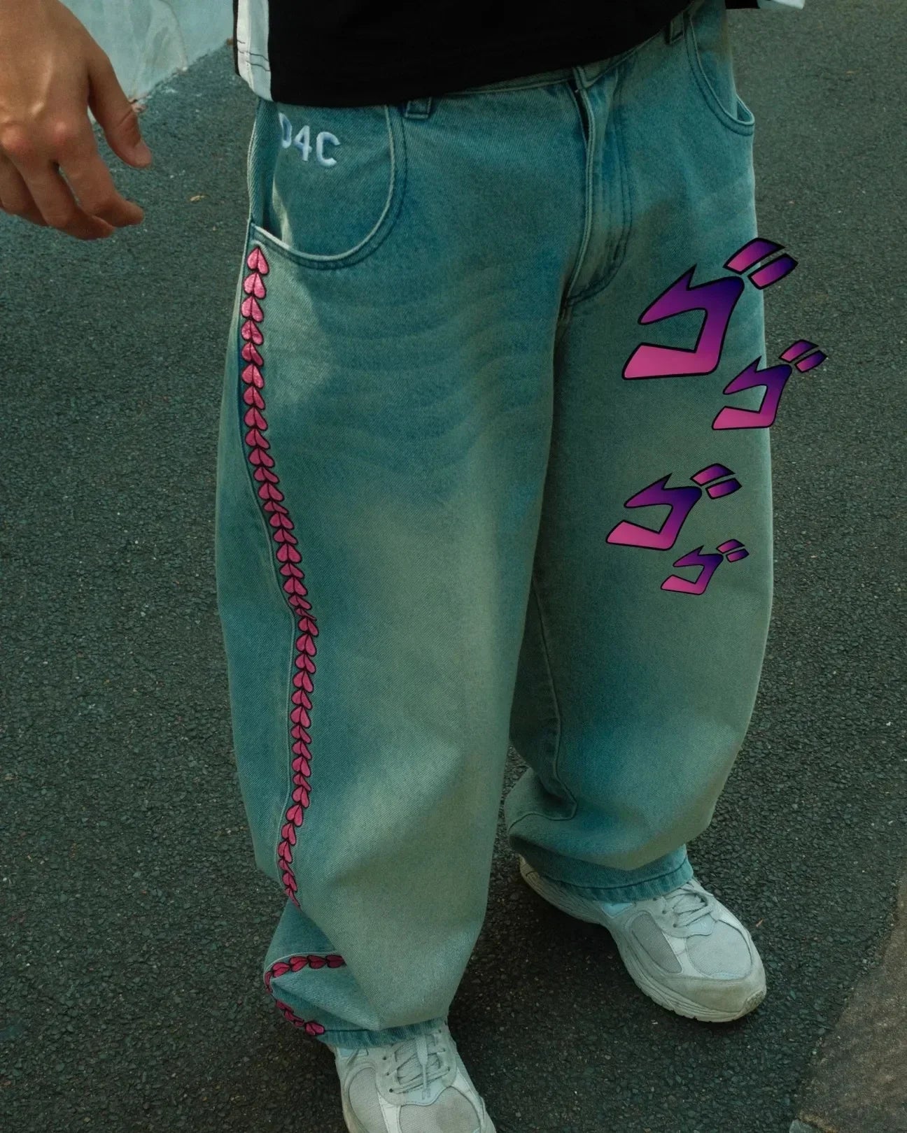 Light blue jeans with pink stitching and purple designs on a pavement background