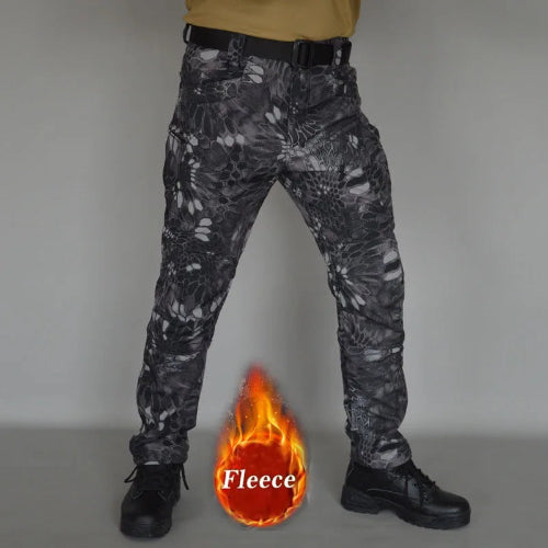 Front view of a model wearing gray and black patterned cargo pants with a black belt and black lace-up boots, alongside a fleece label graphic against a gray background.
