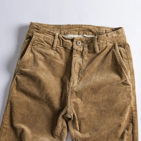 A pair of brown corduroy pants laid flat against a light gray background.