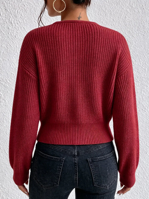 A person shown from the back wearing a ribbed knit long-sleeve sweater in a deep red or burgundy tone, 