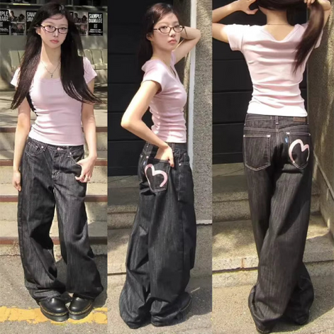 Woman modeling dark-wash loose-fit jeans with contrast stitching and a pink heart outline on a back pocket, shown from the front, side, and back.⠋