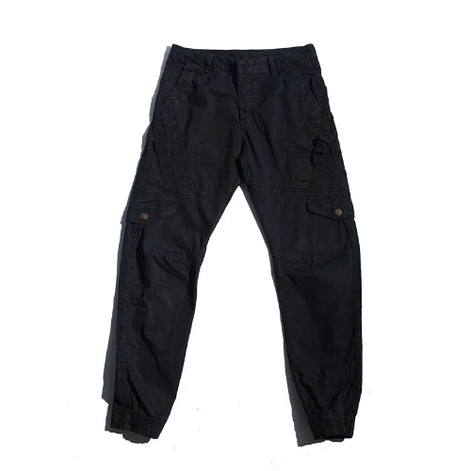 Black cargo pants laid flat against a white background, showing angled thigh pockets, buttoned flap pockets, side straps, and gathered ankle cuffs.