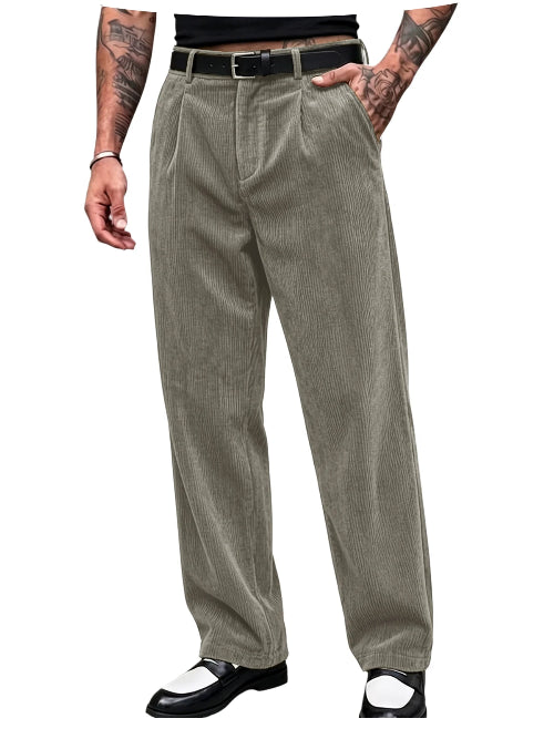 A pair of men's relaxed-fit corduroy trousers in a muted sage green color, styled with a black belt, black shirt, and black-and-white shoes on a white background.