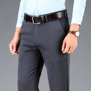 Person wearing gray pants, light blue shirt, brown belt, and watch on a gray background