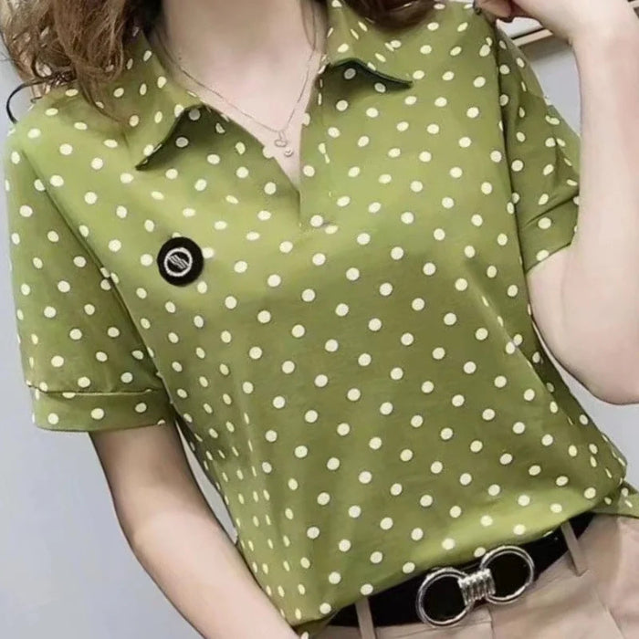 A woman wearing a short-sleeve olive green polo shirt with a white polka dot pattern, paired with beige pants and a black belt with a silver ring buckle.
