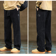 Black pants worn by a person on a brown floor.