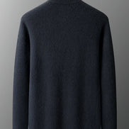 Dark gray sweater on a wooden mannequin against a gray background