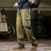 Front-angle view of a model wearing faded olive-brown cargo pants with large flap thigh pockets and straight legs, paired with brown boots.