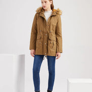Woman wearing a brown parka jacket with fur trim on a white background