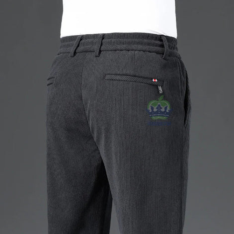 Dark gray corduroy pants with a logo on the back pocket against a gray background