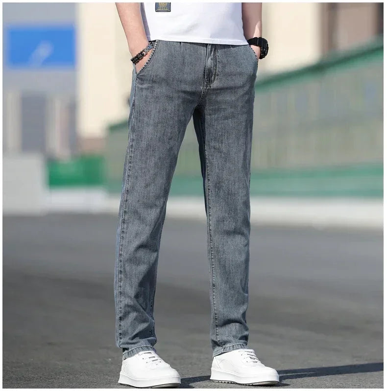 Person wearing gray jeans and white sneakers on a blurred street background