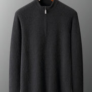 Dark gray sweater on a hanger against a gray background