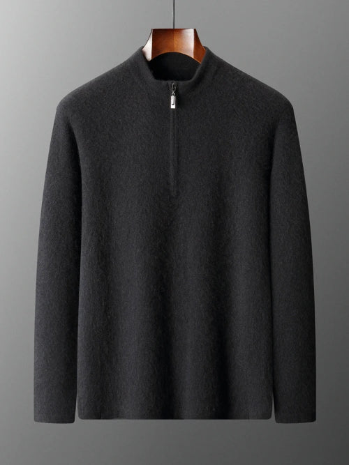 Dark gray sweater on a hanger against a gray background