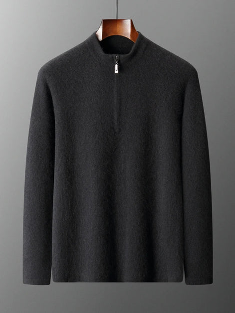 Dark gray sweater on a hanger against a gray background