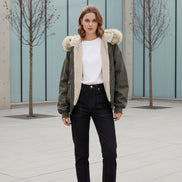 Green jacket with fur hood and trim worn by a model, brand 'ZAROY' visible.