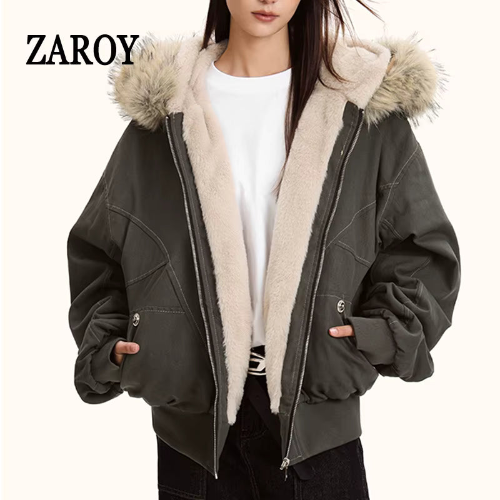 Model wearing a dark gray hooded jacket open, showing light fur-look hood trim, cream plush-look lining, a front zipper and ribbed cuffs and waistband