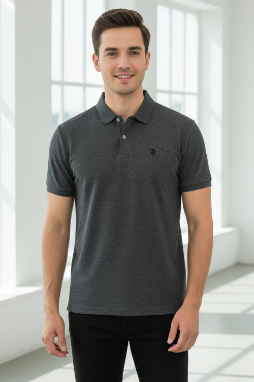 Gray polo shirt with a red logo held by a hand, with other colored shirts hanging in the background.