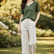 Woman wearing a green knitted sweater with a blurred background