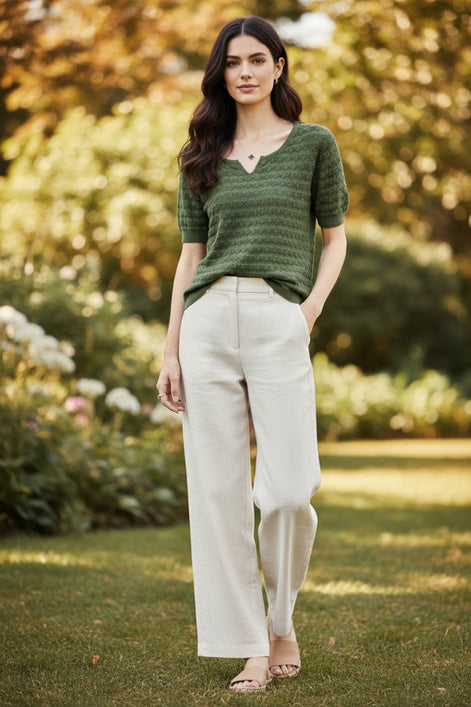 Woman wearing a green knitted sweater with a blurred background