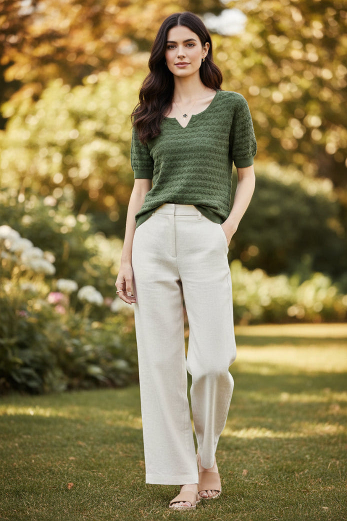 Woman wearing a green knitted sweater with a blurred background
