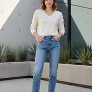 Woman wearing a white sweater against a black background
