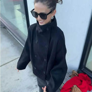 Angled overhead view of a woman wearing a dark stand-collar short coat outdoors