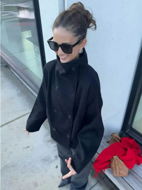 Angled overhead view of a woman wearing a dark stand-collar short coat outdoors