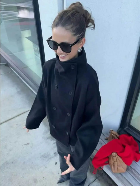 Angled overhead view of a woman wearing a dark stand-collar short coat outdoors