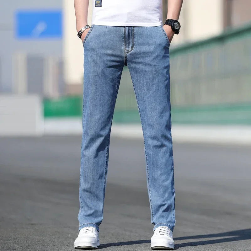 Person wearing light blue jeans and white sneakers on a blurred street background