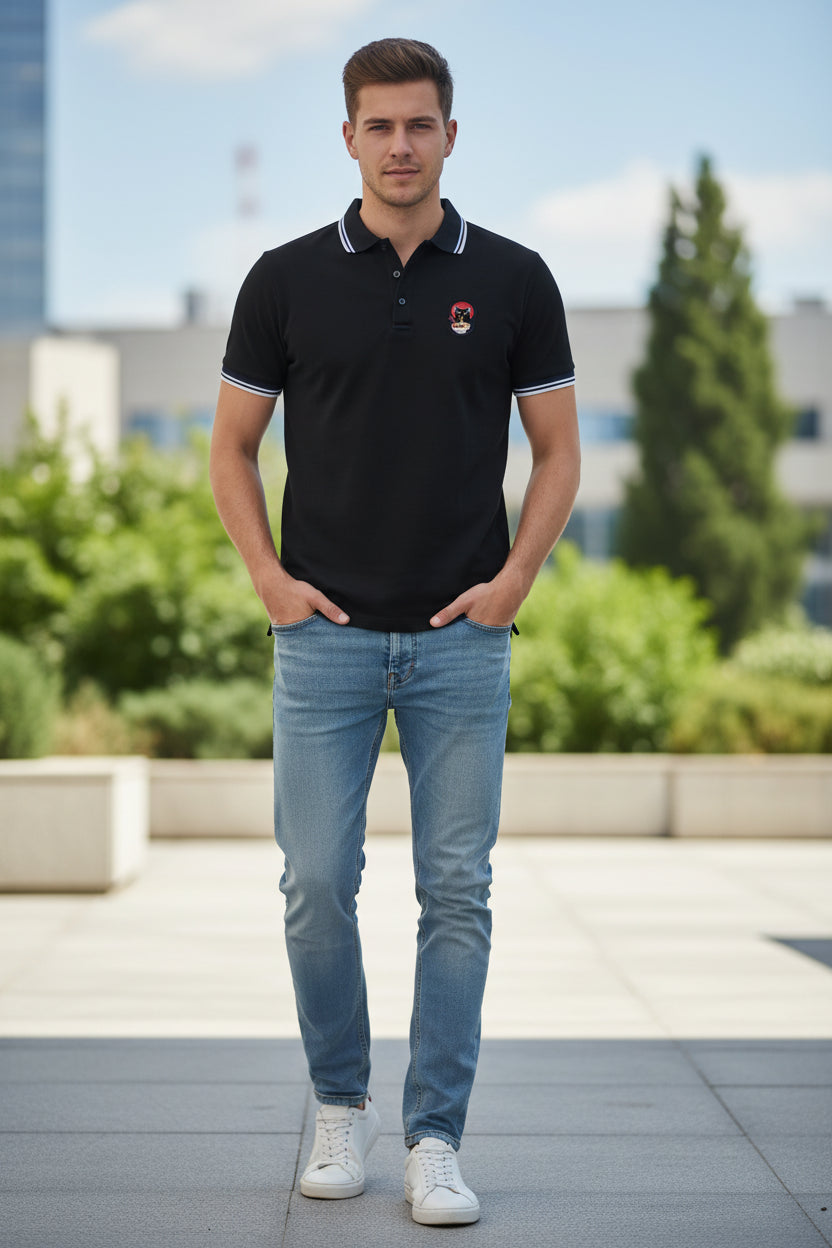 A black short-sleeve polo shirt with a white and navy striped collar, white trim on the sleeve cuffs, and a small embroidered graphic on the left chest.