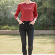 Person wearing a red long-sleeve shirt with a neutral background