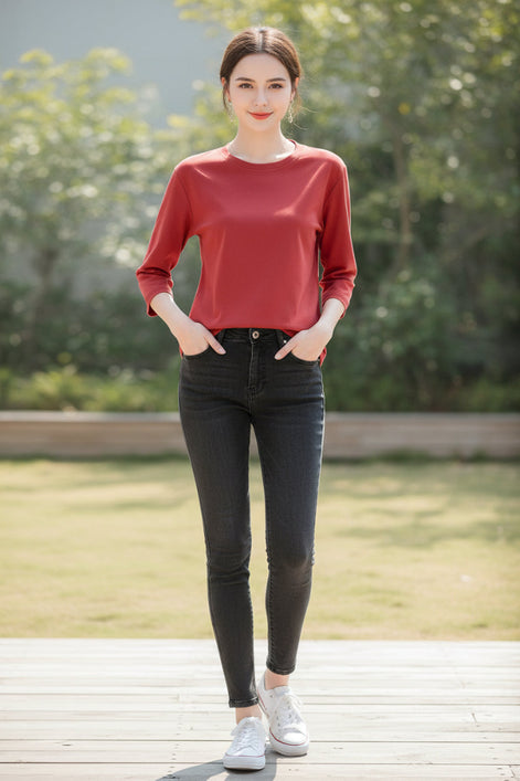 Person wearing a red long-sleeve shirt with a neutral background