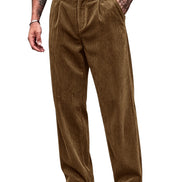 A person wearing brown corduroy trousers with a black belt, paired with black-and-white shoes, shown from the waist down on a plain white background.