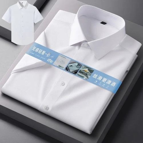 A folded white long-sleeve dress shirt with a pointed collar and button front, shown on a dark gray display surface. A blue product tag wraps around the shirt, 