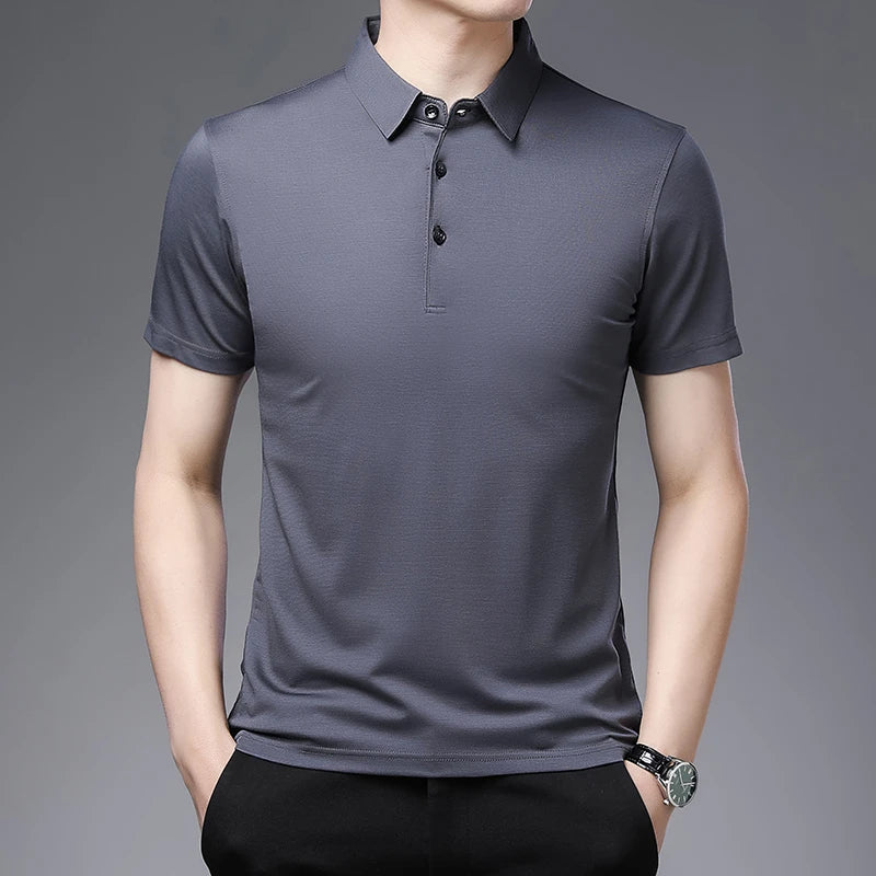 Man wearing a gray polo shirt against a gray background