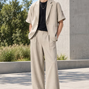 A men's two-piece casual outfit set featuring a light beige short-sleeve blazer layered over a black t-shirt,