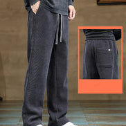 Person wearing dark gray sweatpants with a close-up inset showing a pocket detail.