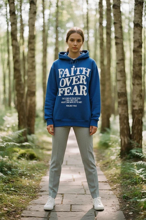 Blue hoodie with 'Faith Over Fear' text on a wooden surface