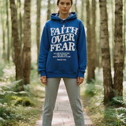 Blue hoodie with 'Faith Over Fear' text on a wooden surface